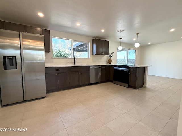 8324 E Beverly St, Tucson, AZ 85710 - kitchen with appliances with stainless steel finishes, healthy amount of natural light, a peninsula, light countertops, and recessed lighting