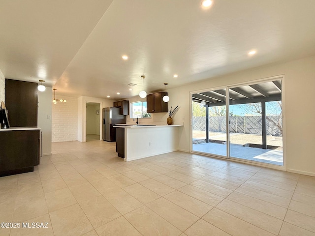 8324 E Beverly St, Tucson, AZ 85710 - kitchen with stainless steel fridge, light tile patterned floors, open floor plan, light countertops, and recessed lighting