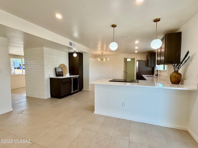 8324 E Beverly St, Tucson, AZ 85710 - kitchen featuring dark brown cabinetry, light countertops, black electric cooktop, light tile patterned floors, and recessed lighting