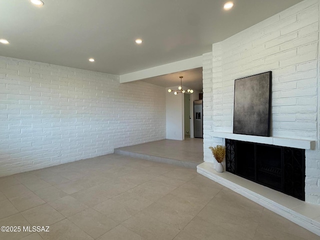 8324 E Beverly St, Tucson, AZ 85710 - unfurnished room featuring a chandelier, tile patterned flooring, brick wall, a large fireplace, and recessed lighting