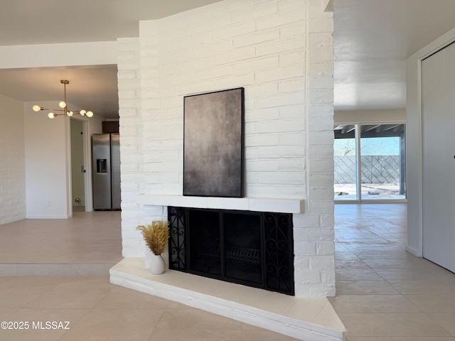 8324 E Beverly St, Tucson, AZ 85710 - detailed view of stainless steel fridge with ice dispenser, a multi sided fireplace, and a chandelier