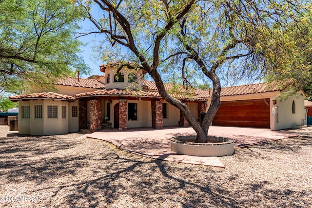 2301 W Holladay St, Tucson, AZ 85746 - mediterranean / spanish house with a tiled roof, stucco siding, and driveway