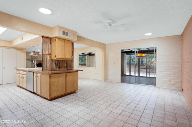 149 E La Huerta, Green Valley, AZ 85614 - kitchen with ceiling fan, open floor plan, dishwasher, a textured ceiling, and brick wall