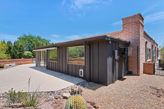149 E La Huerta, Green Valley, AZ 85614 - view of side of home with board and batten siding, a patio area, and a chimney