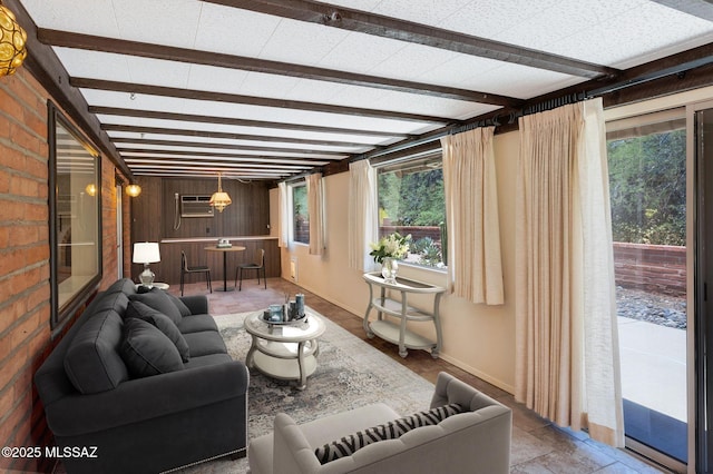 149 E La Huerta, Green Valley, AZ 85614 - living room featuring plenty of natural light, beamed ceiling, a wall mounted AC, and wooden walls