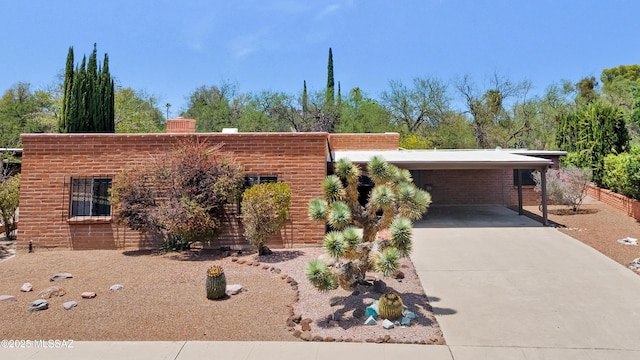 149 E La Huerta, Green Valley, AZ 85614 - view of front of home featuring concrete driveway, brick siding, an attached carport, and a chimney
