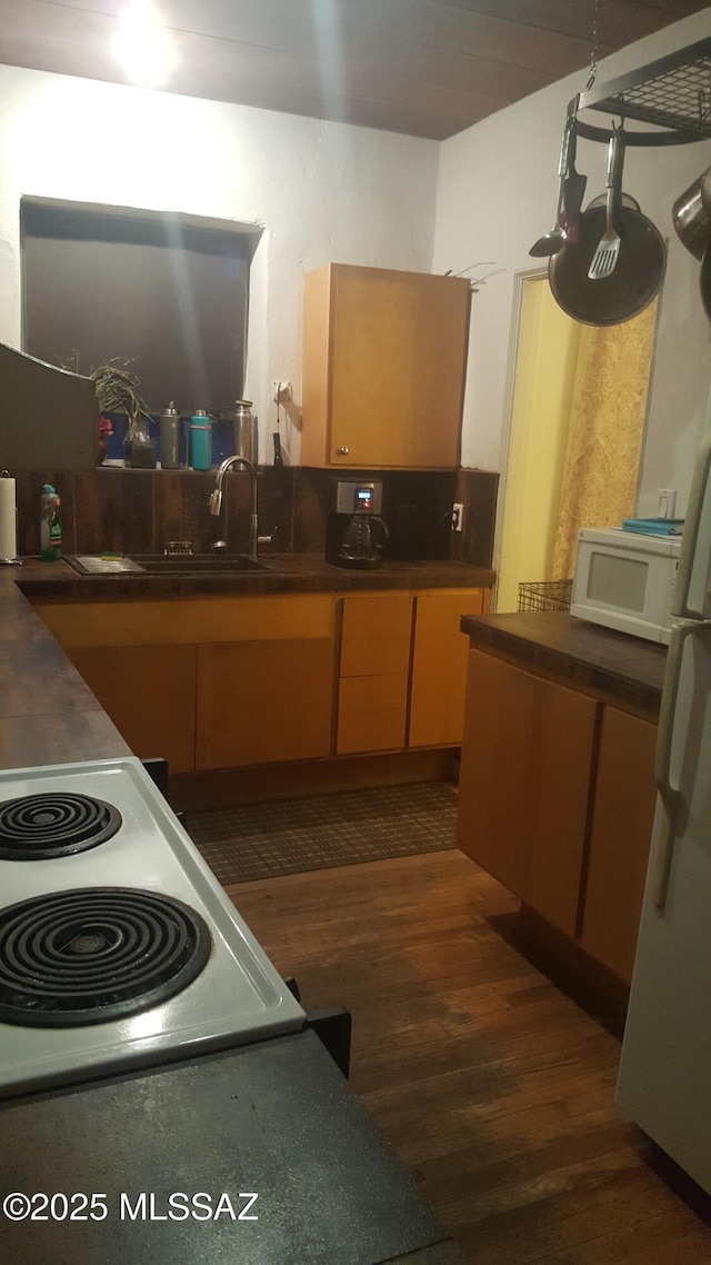 1816 E Waverly St, Tucson, AZ 85719 - kitchen with white microwave, dark wood-type flooring, dark countertops, and range