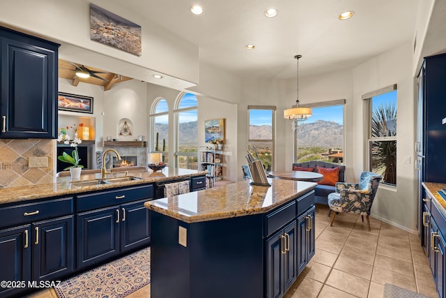 1511 E Placita Meseta Dorada, Oro Valley, AZ 85755 - kitchen featuring blue cabinetry, recessed lighting, a lit fireplace, a mountain view, and a center island