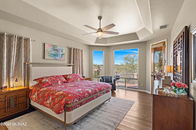 1511 E Placita Meseta Dorada, Oro Valley, AZ 85755 - bedroom with a tray ceiling, access to outside, wood finished floors, and a ceiling fan