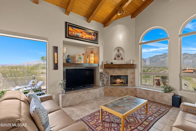 1511 E Placita Meseta Dorada, Oro Valley, AZ 85755 - living area with a tiled fireplace, a wood ceiling with exposed beams, tile patterned flooring, and high vaulted ceiling