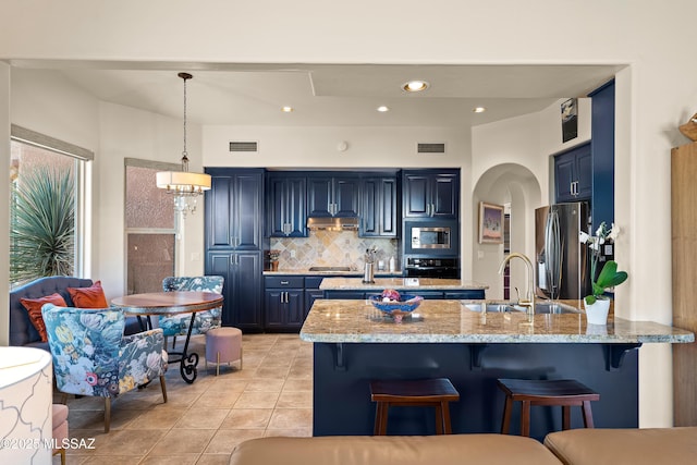 1511 E Placita Meseta Dorada, Oro Valley, AZ 85755 - kitchen with appliances with stainless steel finishes, blue cabinets, a breakfast bar, tasteful backsplash, and recessed lighting