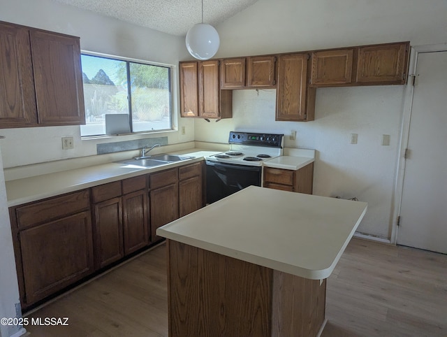 7088 S Camino Grande, Tucson, AZ 85746 - kitchen featuring range with electric stovetop, light wood-type flooring, a textured ceiling, brown cabinets, and decorative light fixtures