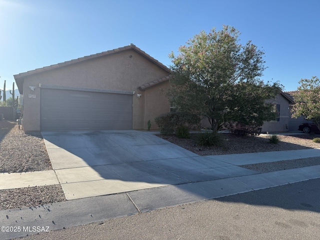 9150 N Wagon Spoke Ct, Tucson, AZ 85742 - view of front of property with stucco siding, a garage, driveway, and a tiled roof
