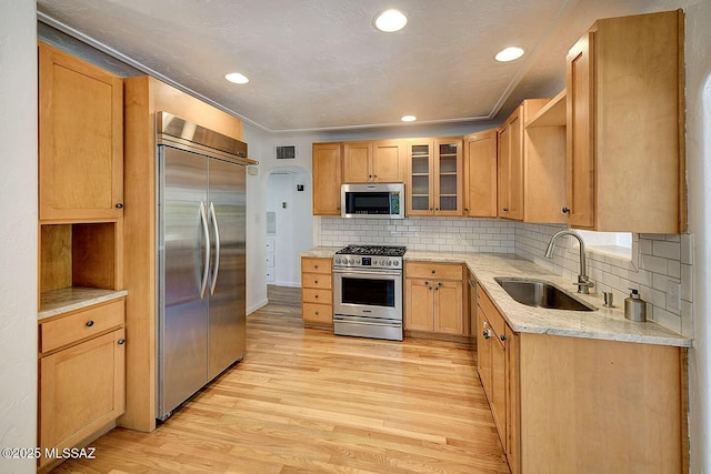 2421 E Drachman St, Tucson, AZ 85719 - kitchen featuring high quality appliances, open shelves, light wood-style flooring, light stone countertops, and decorative backsplash