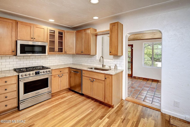 2421 E Drachman St, Tucson, AZ 85719 - kitchen with stainless steel appliances, arched walkways, tasteful backsplash, recessed lighting, and glass insert cabinets
