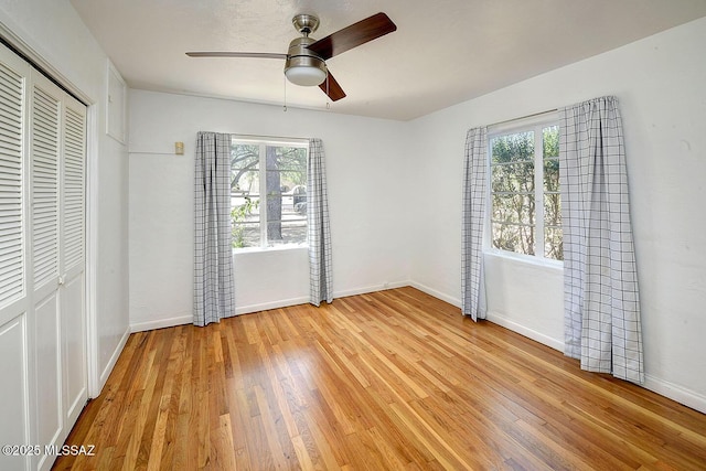 2421 E Drachman St, Tucson, AZ 85719 - unfurnished bedroom featuring multiple windows, light wood-type flooring, a closet, and ceiling fan