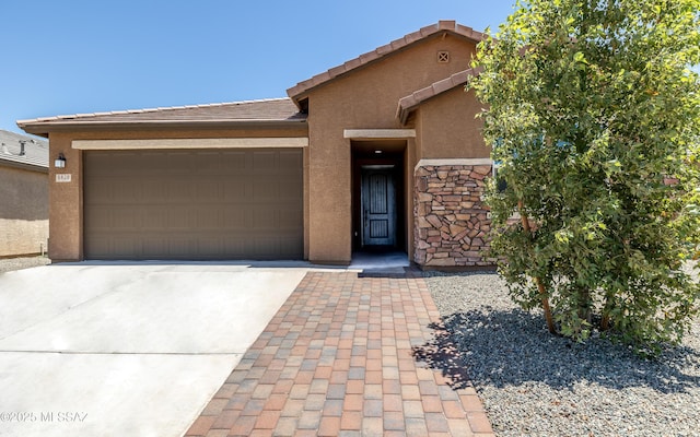 8820 E Stone Meadow Cir, Tucson, AZ 85730 - view of front facade with stucco siding, concrete driveway, a garage, stone siding, and a tile roof