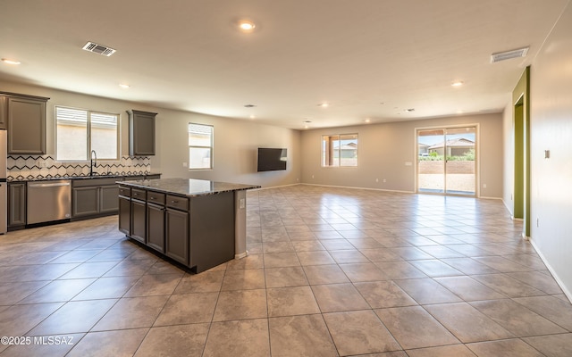 8820 E Stone Meadow Cir, Tucson, AZ 85730 - kitchen with stainless steel dishwasher, tasteful backsplash, a center island, recessed lighting, and open floor plan