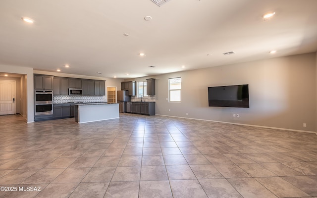 8820 E Stone Meadow Cir, Tucson, AZ 85730 - kitchen featuring open floor plan, stainless steel appliances, tasteful backsplash, gray cabinetry, and recessed lighting