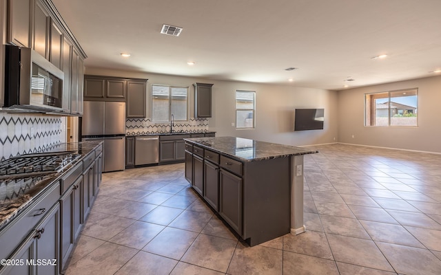 8820 E Stone Meadow Cir, Tucson, AZ 85730 - kitchen with stainless steel appliances, plenty of natural light, backsplash, dark stone countertops, and recessed lighting