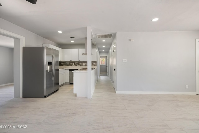 5609 E Juarez St, Tucson, AZ 85711 - kitchen with stainless steel appliances, open floor plan, light countertops, white cabinets, and backsplash