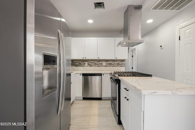 5609 E Juarez St, Tucson, AZ 85711 - kitchen featuring appliances with stainless steel finishes, wall chimney range hood, light marble finish flooring, light stone countertops, and white cabinetry
