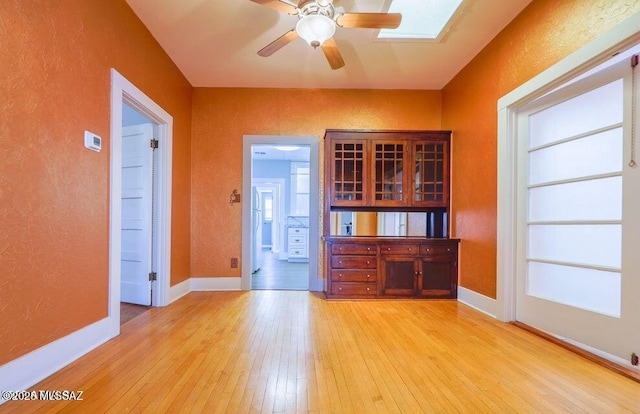 201 B St, Bisbee, AZ 85603 - unfurnished room featuring light wood-style flooring, a textured wall, a ceiling fan, and a skylight