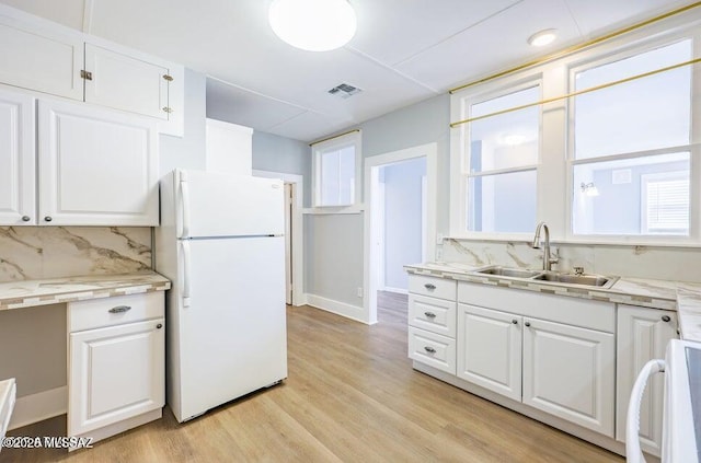 201 B St, Bisbee, AZ 85603 - kitchen with freestanding refrigerator, white cabinets, backsplash, and light countertops
