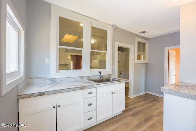 201 B St, Bisbee, AZ 85603 - kitchen featuring glass insert cabinets, white cabinetry, and light wood finished floors