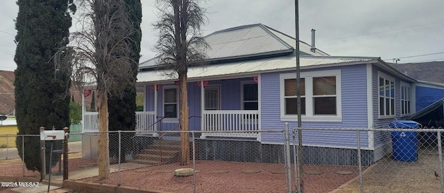 201 B St, Bisbee, AZ 85603 - view of front facade featuring covered porch, a fenced front yard, a gate, and a metal roof