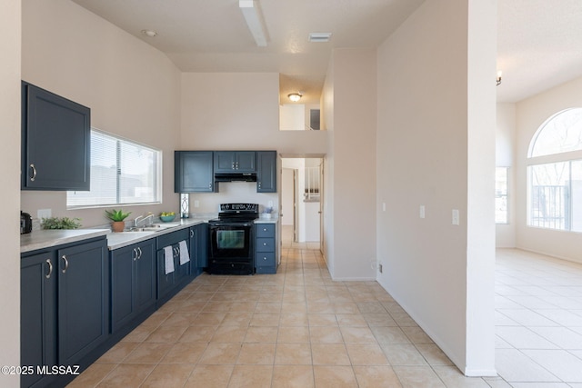 3556 W Avenida Del Mar, Tucson, AZ 85746 - kitchen featuring electric range, under cabinet range hood, light countertops, light tile patterned flooring, and a towering ceiling