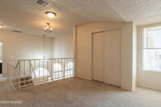 3556 W Avenida Del Mar, Tucson, AZ 85746 - unfurnished bedroom with carpet, a chandelier, a textured ceiling, multiple windows, and lofted ceiling
