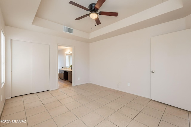 3556 W Avenida Del Mar, Tucson, AZ 85746 - unfurnished bedroom with a tray ceiling, light tile patterned flooring, a closet, and ensuite bath