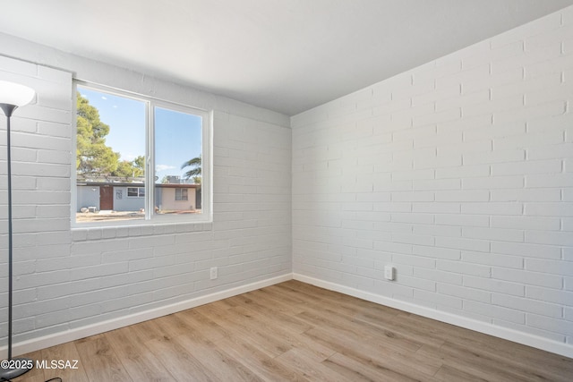 3872 S Evergreen Ave, Tucson, AZ 85730 - unfurnished room with wood finished floors and brick wall