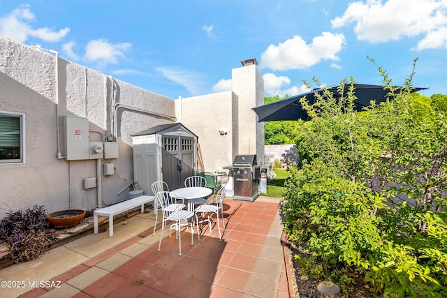 1939 S San Vincent Dr, Green Valley, AZ 85614 - view of patio / terrace featuring a storage unit, a grill, and outdoor dining area