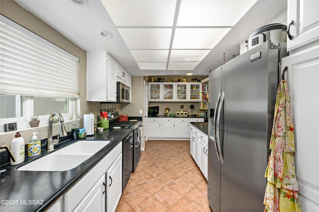 1939 S San Vincent Dr, Green Valley, AZ 85614 - kitchen with stainless steel appliances, dark countertops, white cabinetry, light tile patterned flooring, and glass insert cabinets