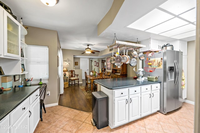 1939 S San Vincent Dr, Green Valley, AZ 85614 - kitchen featuring stainless steel fridge with ice dispenser, dark countertops, light tile patterned flooring, and white cabinetry