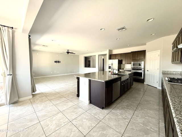 9636 N Havenwood Way, Marana, AZ 85653 - kitchen featuring appliances with stainless steel finishes, open floor plan, ceiling fan, a kitchen island with sink, and light tile patterned floors