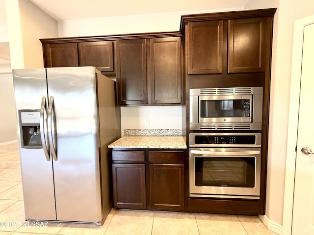 9636 N Havenwood Way, Marana, AZ 85653 - kitchen featuring appliances with stainless steel finishes, light tile patterned flooring, dark brown cabinetry, and light stone counters