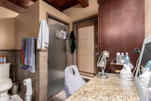 10901 N Camino De Oeste, Tucson, AZ 85742 - bathroom featuring tile walls, a wainscoted wall, a shower stall, and a wooden ceiling with exposed beams