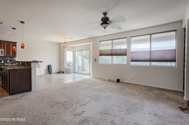 817 E Deer Spring Canyon Pl, Sahuarita, AZ 85629 - unfurnished living room featuring a ceiling fan, a chandelier, and light carpet