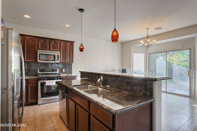 817 E Deer Spring Canyon Pl, Sahuarita, AZ 85629 - kitchen with stainless steel appliances, tasteful backsplash, light tile patterned floors, an island with sink, and dark stone countertops