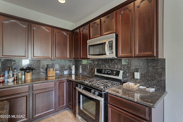 817 E Deer Spring Canyon Pl, Sahuarita, AZ 85629 - kitchen featuring appliances with stainless steel finishes, dark stone counters, backsplash, light tile patterned floors, and dark brown cabinetry