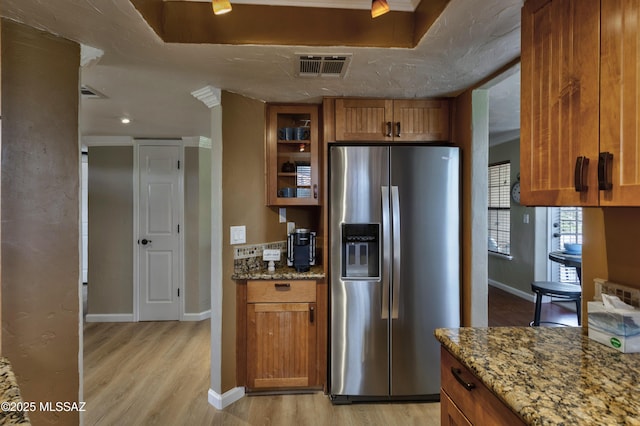 6651 N Campbell Ave Unit 286, Tucson, AZ 85718 - kitchen with stainless steel fridge, brown cabinetry, light wood finished floors, and stone counters