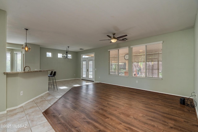 9223 N Crimson Stone Pl, Tucson, AZ 85743 - unfurnished living room featuring plenty of natural light, french doors, a ceiling fan, and light wood-style floors