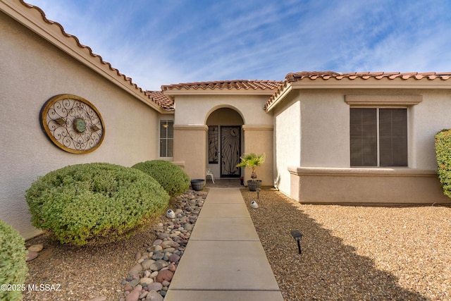 9223 N Crimson Stone Pl, Tucson, AZ 85743 - view of exterior entry featuring stucco siding and a tile roof