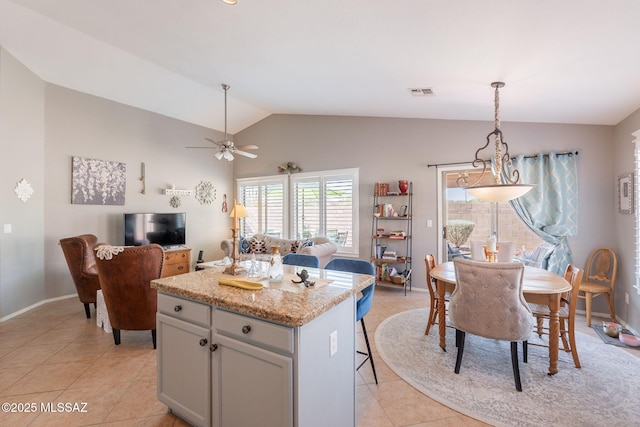 9908 E Shadow Glen Ct, Tucson, AZ 85748 - kitchen with lofted ceiling, light tile patterned flooring, open floor plan, a kitchen island, and ceiling fan