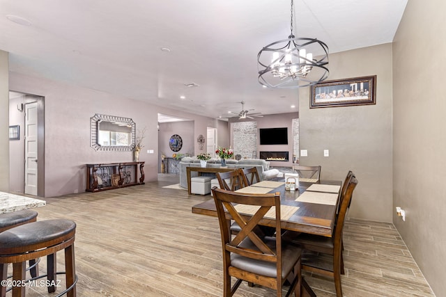 3188 W Tumamoc Dr, Tucson, AZ 85745 - dining area featuring a glass covered fireplace, ceiling fan, light wood-type flooring, a chandelier, and recessed lighting