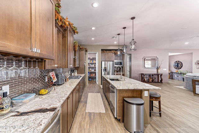3188 W Tumamoc Dr, Tucson, AZ 85745 - kitchen with light wood finished floors, appliances with stainless steel finishes, a kitchen bar, tasteful backsplash, and recessed lighting