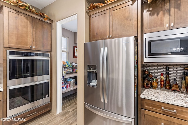 3188 W Tumamoc Dr, Tucson, AZ 85745 - kitchen featuring appliances with stainless steel finishes, light wood finished floors, and light stone countertops